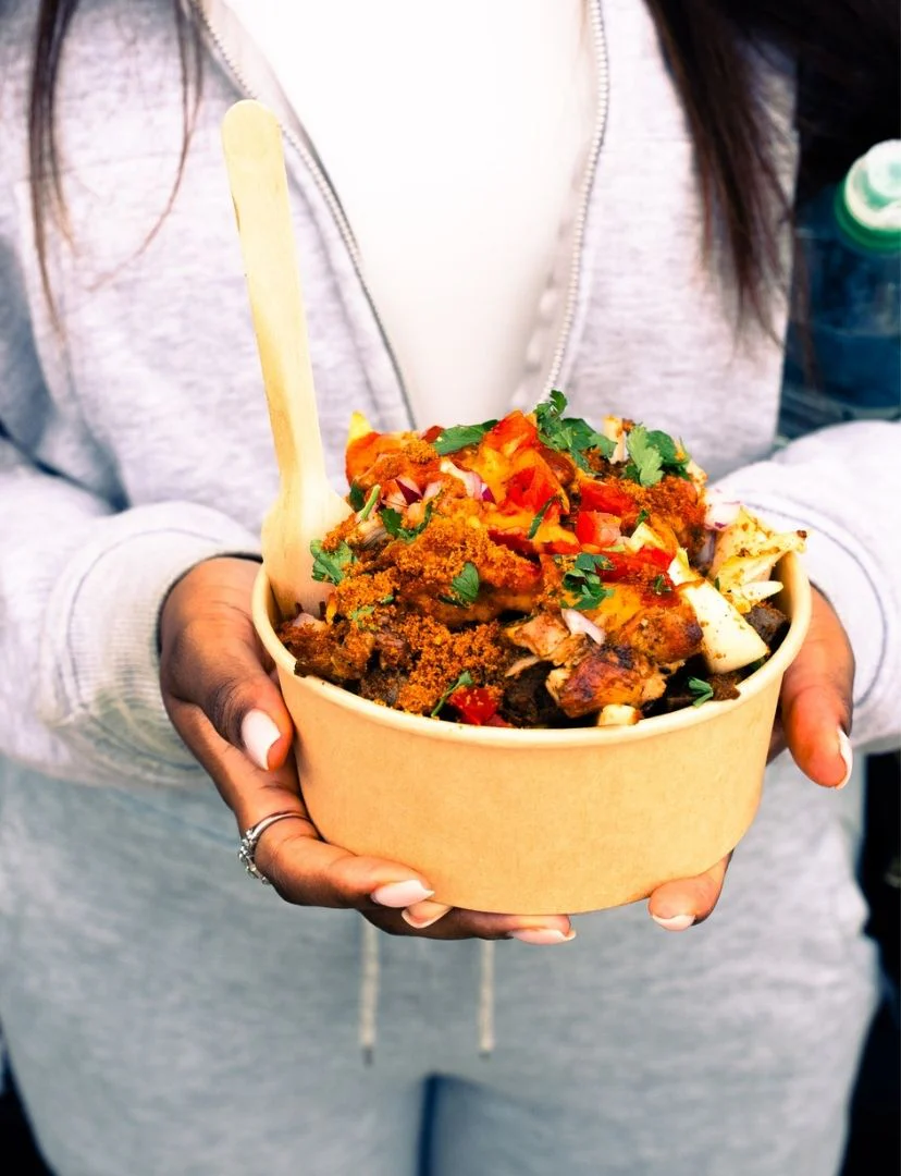 Hands holding a vibrant bowl of vegan diaspora food